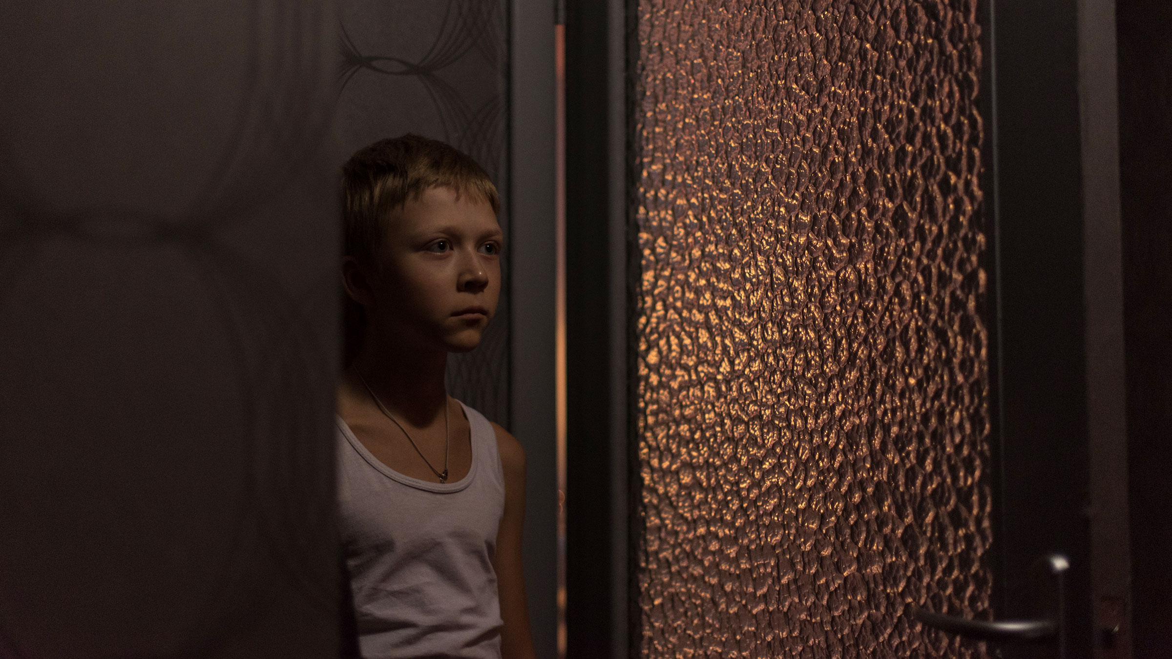 Chlapec z filmu Nemilovaní stojící za dveřmi