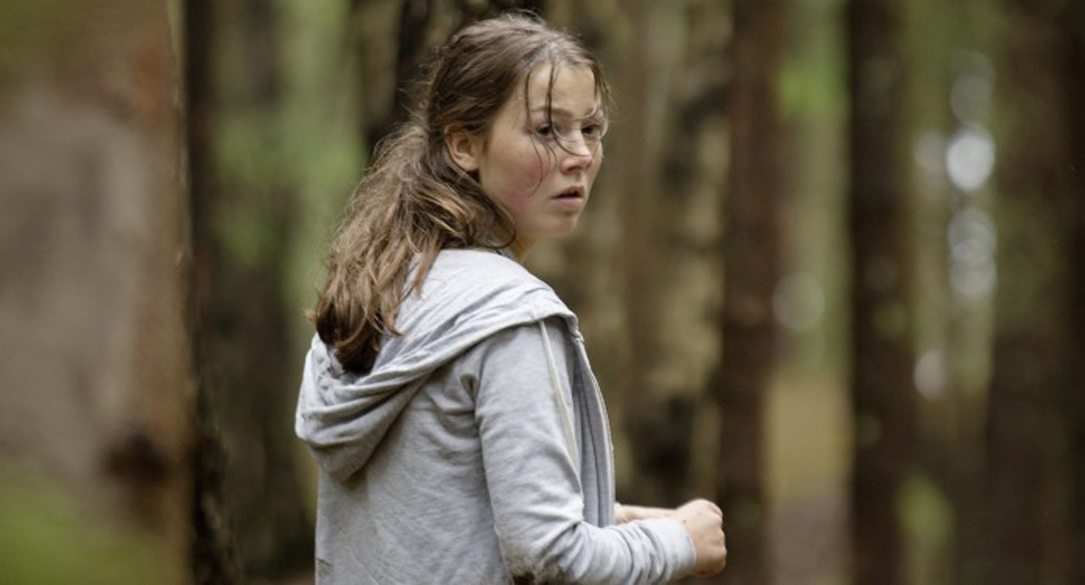 Herečka Andrea Berntzenová prchá lesem ve filmu Utøya 22. července