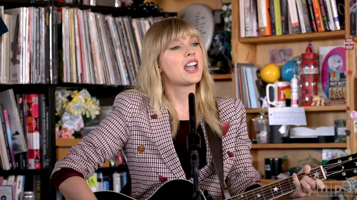 Taylor Swift s kytarou během kancelářského koncertu