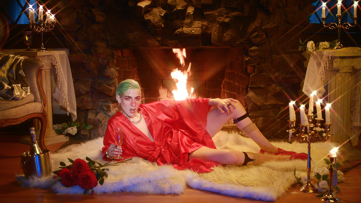 Dorian Electra v saténovém červeném kimonu leží před hořícím krbem