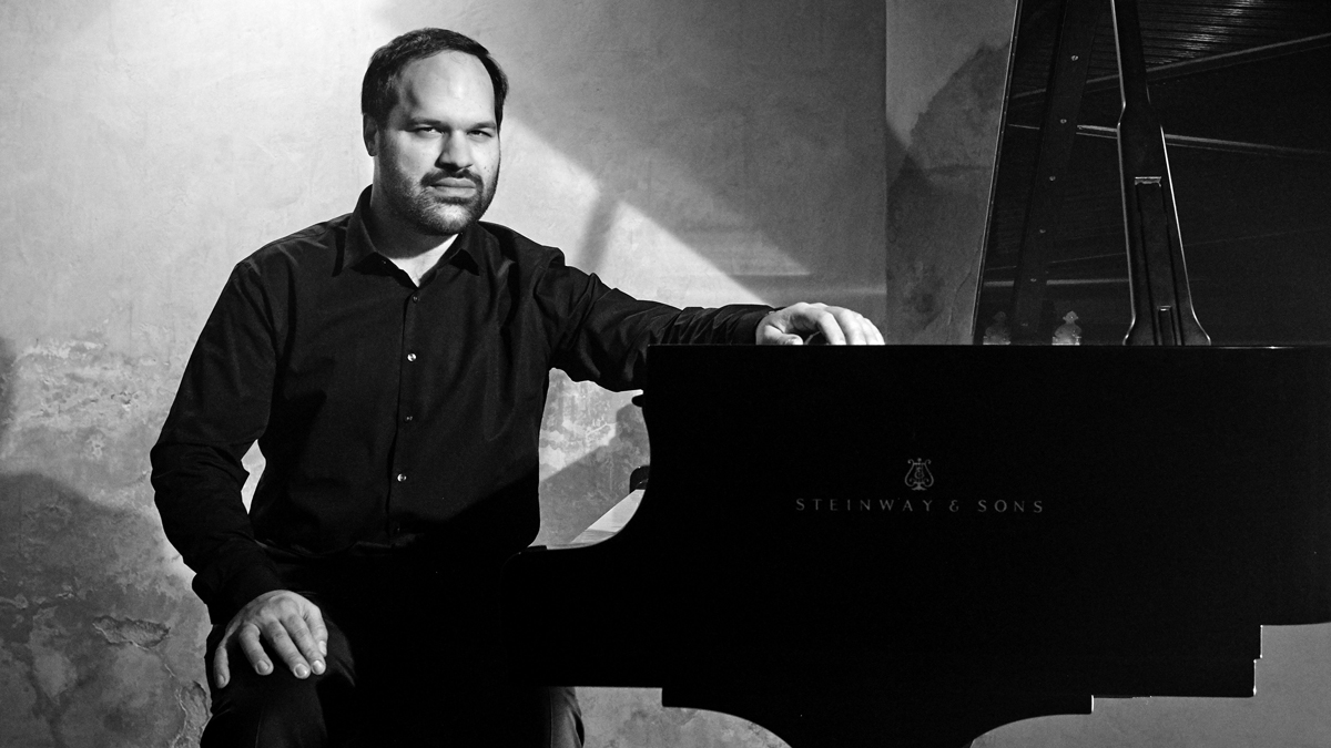 Jan Bartoš sedí u klavíru