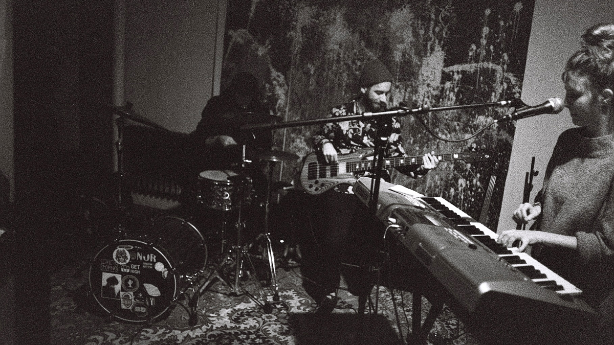 Zpívající klávesistka, v pozadí kytarista a bubeník