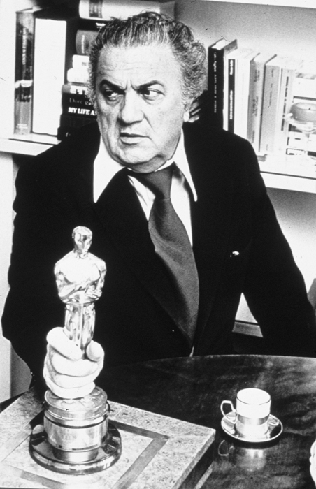 Fellini u stolu, v ruce drží sošku Oscara