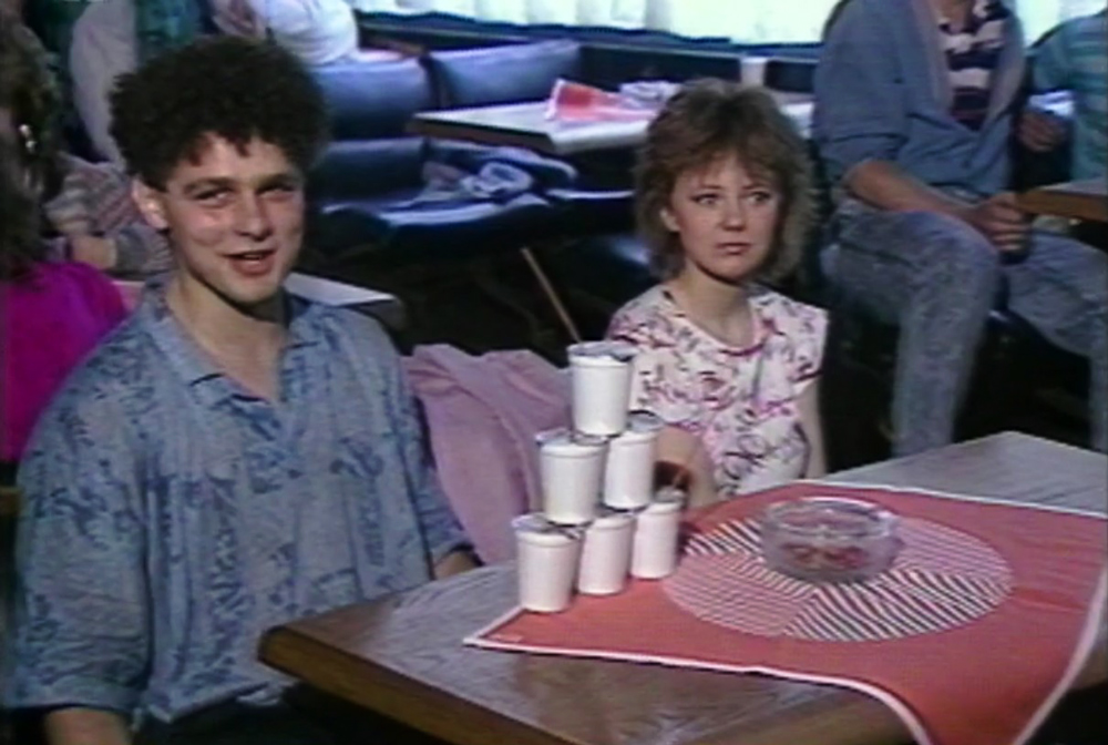 mladík a dívka u stolu s kelímky jogurtu