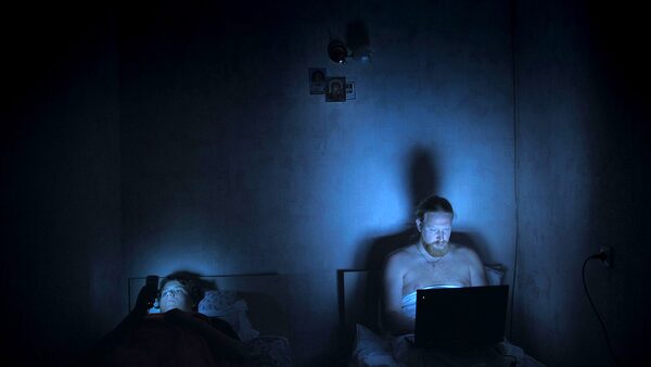 V hotelových postelích: otec s notebookem, syn s mobilem