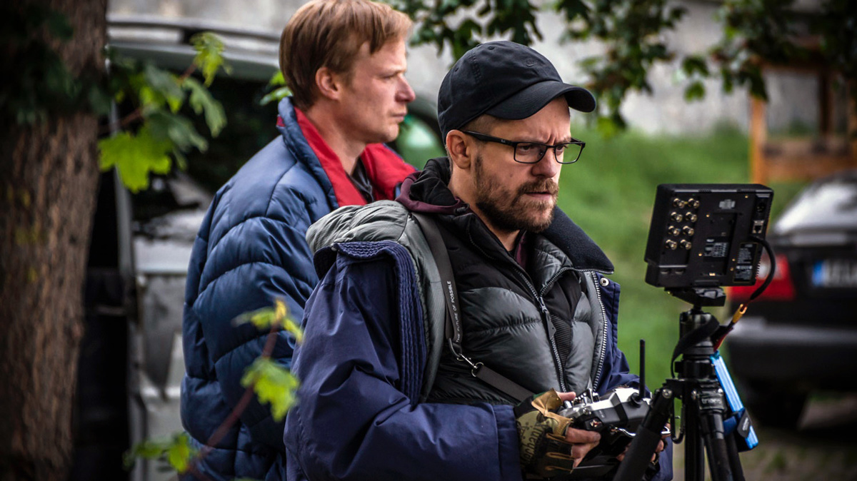 Jiří Mádl drží ovladač dronu a&nbsp;dívá se na monitor, v&nbsp;pozadí Kryštof Hádek