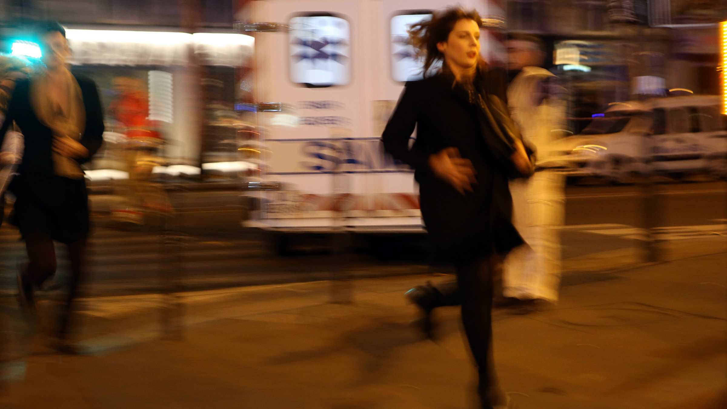 rozmazaný snímek, běžící žena, v pozadí sanitka