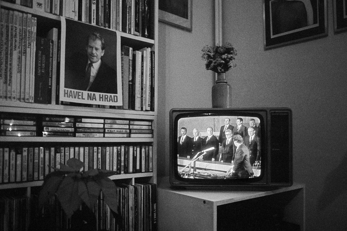 Zátiší s&nbsp;knihovnou, plakátem Václava Havla a&nbsp;televizí v&nbsp;níž je Havel ve sněmovně