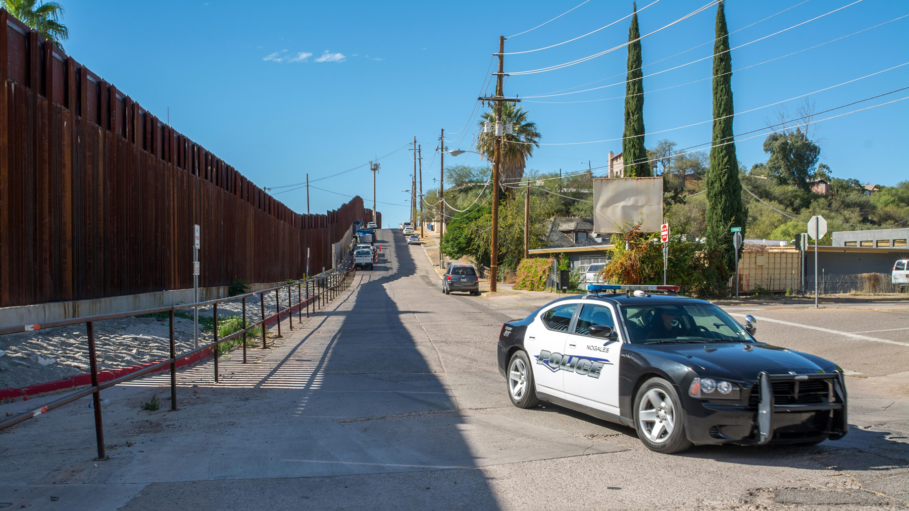 zeď na hranici Arizony a Mexika, v popředí policejní auto
