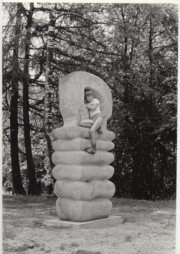 holčička sedící na soše