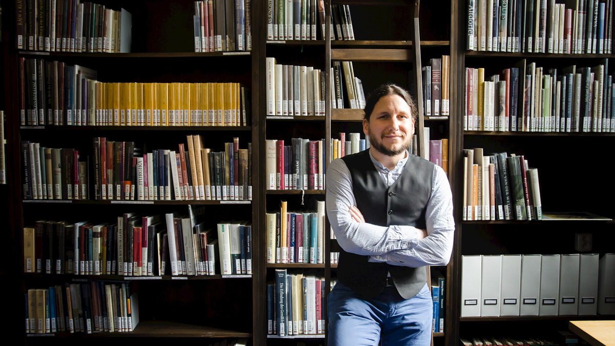 Ivan Foletti stojící před knihovnou