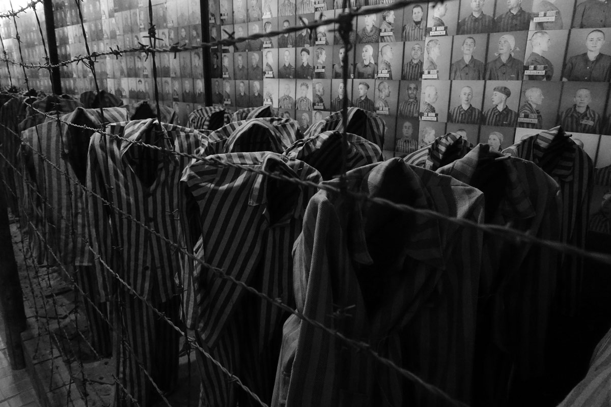 ilustrační snímek vězeňských mundůrů za ostnatým drátem