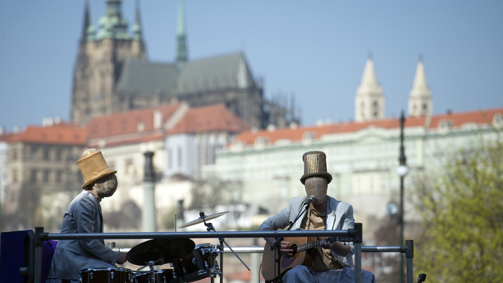Členové souboru nového cirkusu Cirk La Putyka hrajou 9. dubna 2020 pro pobavení lidí v pražských ulicích, v pozadí Pražský hrad