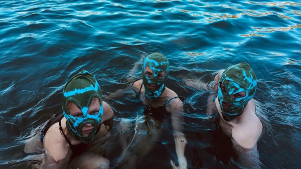 tři lidé ve vodě s maskami na hlavě