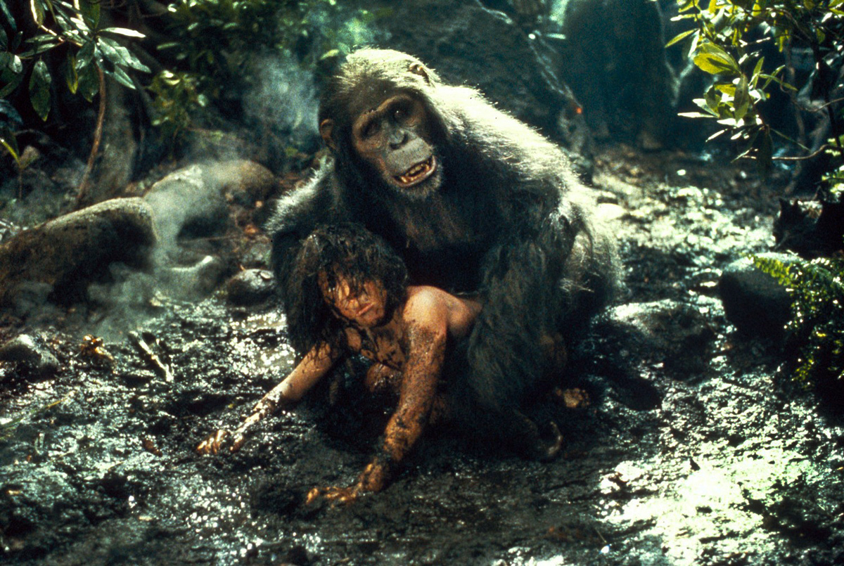 opice leží na Tarzanovi válejícím se v bahně