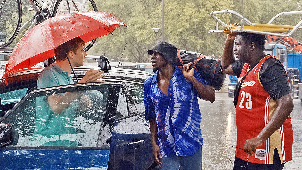 muži hovoří v dešti u auta