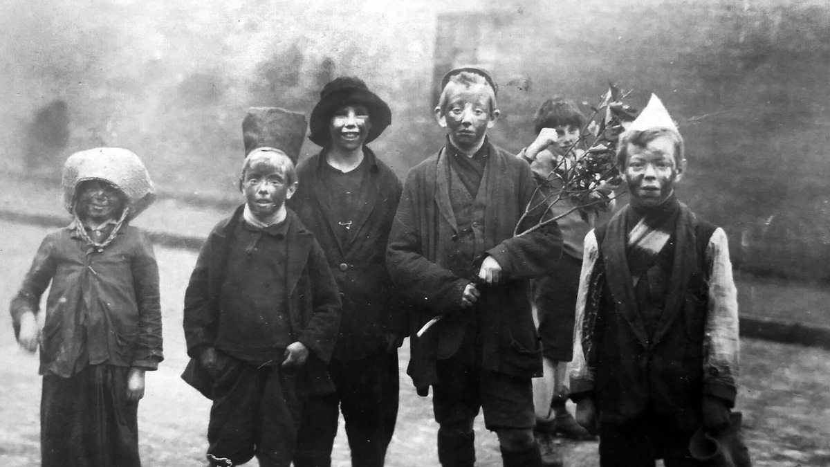 černobílý snímek koledníků v maskách