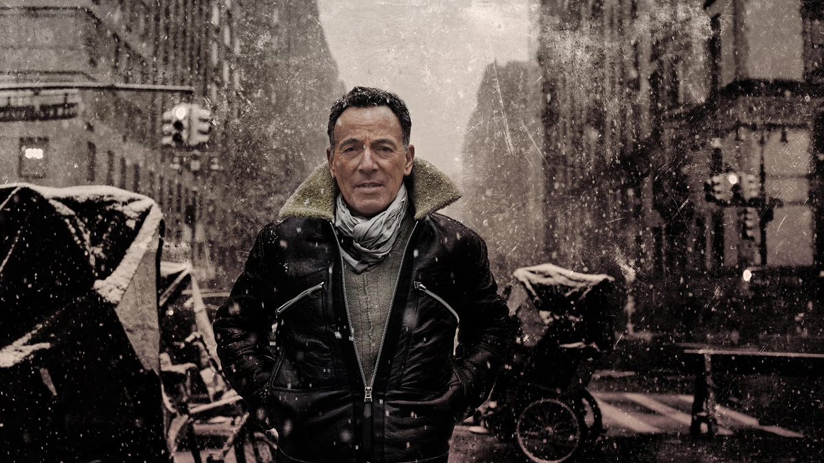 Bruce Springsteen stojí v ulici, v níž padá sníh
