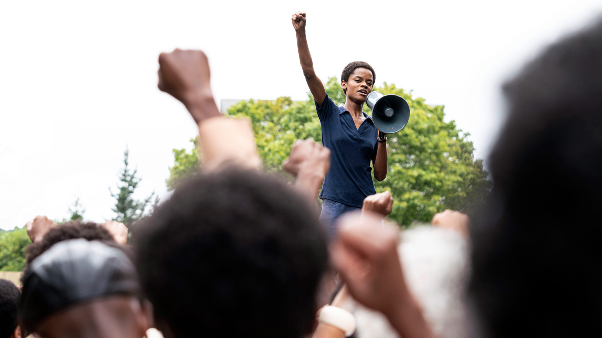 žena se zdviženou rukou a megafonem na demonstraci