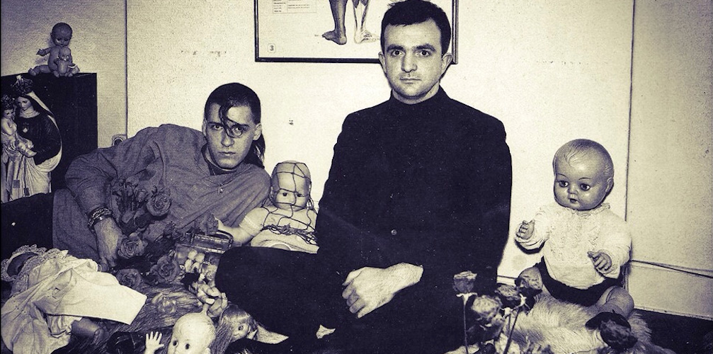 dva muži pózují obloženi panenkami