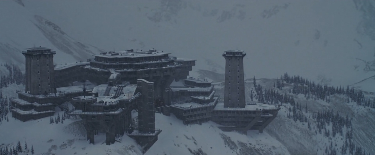 obrovská brutalistní pevnost s věžemi, v horách, zasněženo