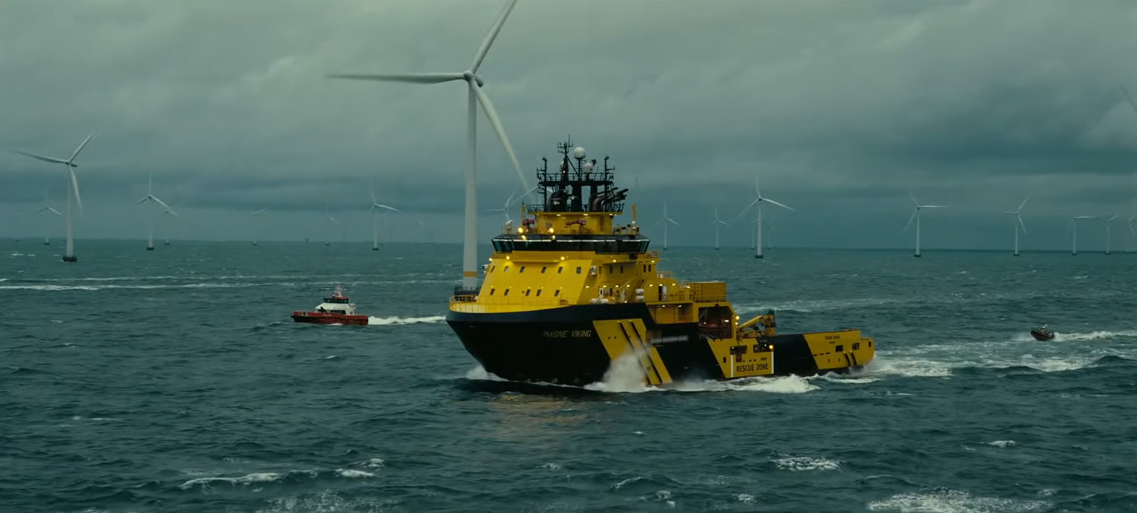 žlutý tanker plující mezi mořskými větrnými elektrárnami