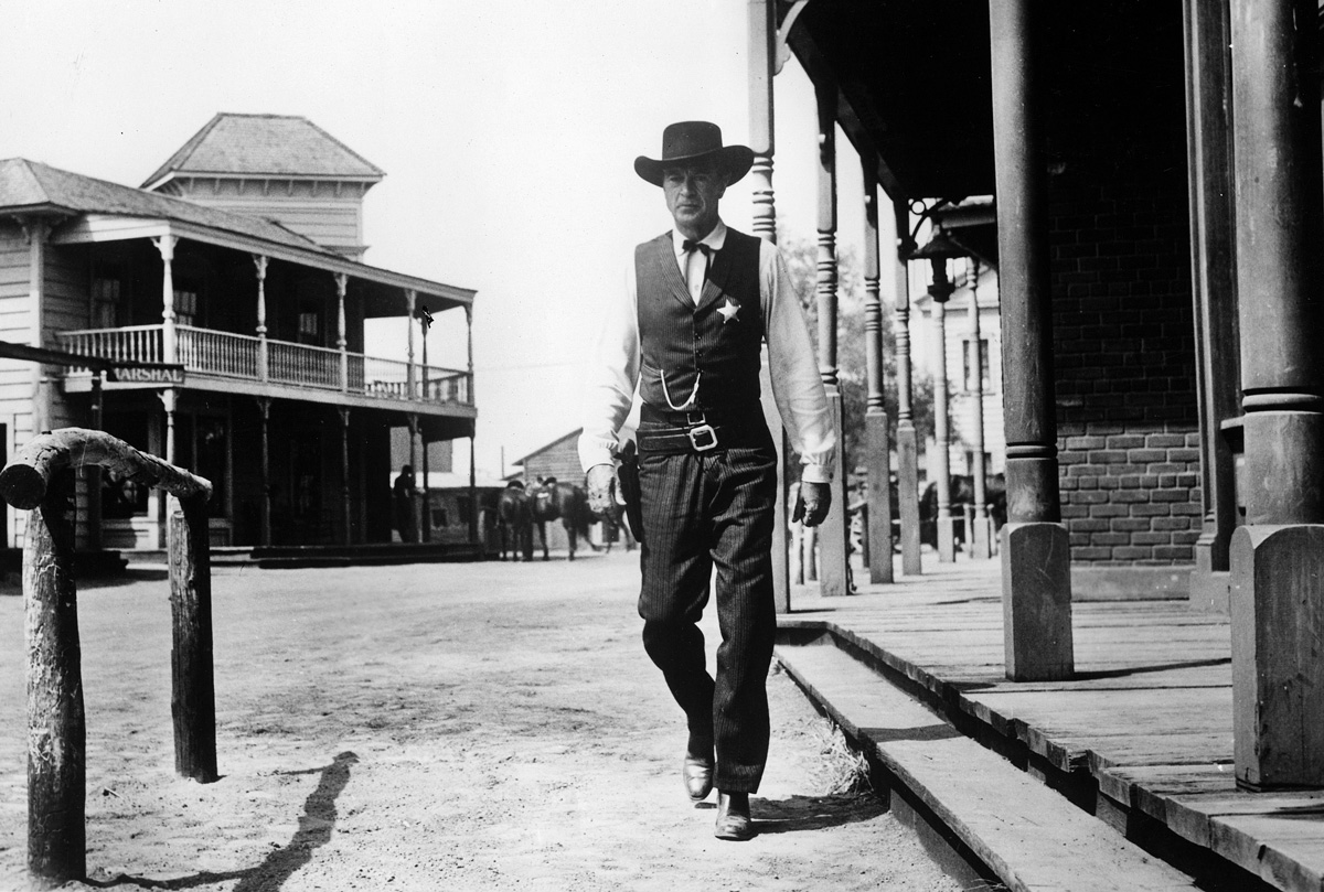 Gary Cooper jako šerif kráčející městečkem