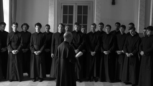 řada mladých mužů v kněžských hábitech