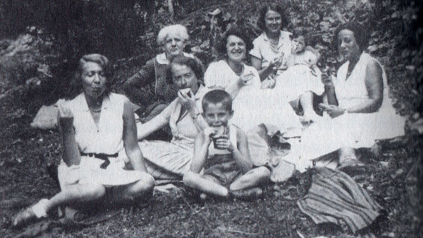 černobílý snímek, rodina svačí v trávě
