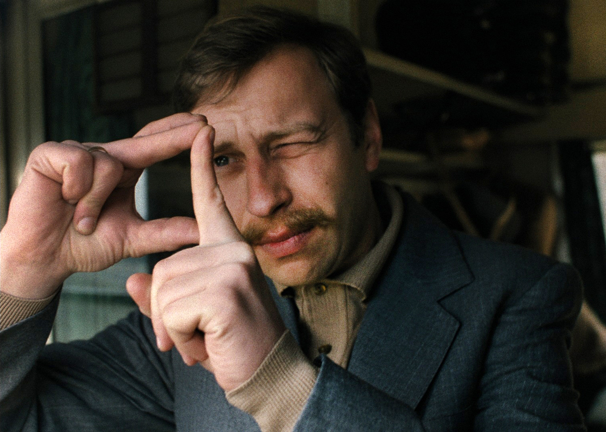 muž promýšlející si záběr pomocí okýnka na prstech