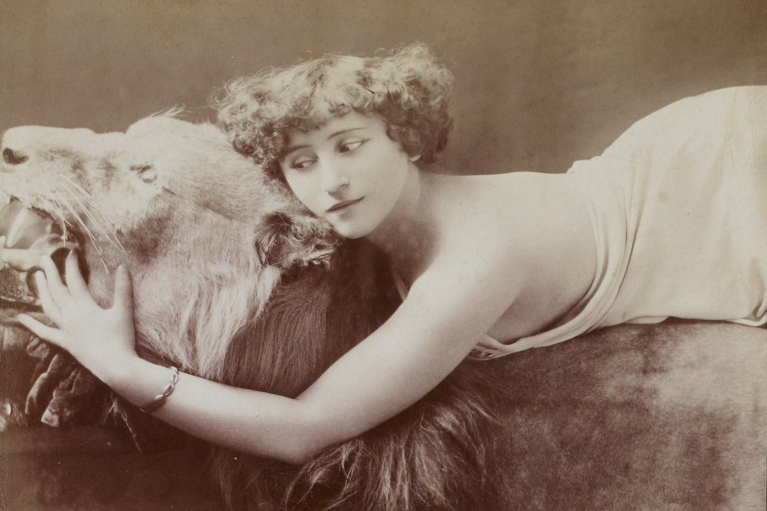 žena ležící na vycpaném lvovi